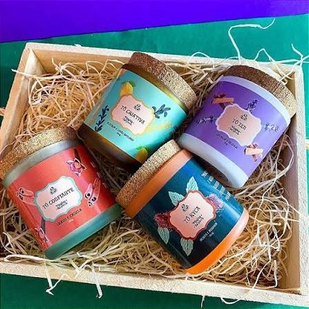 Kit com quatro velas em potes coloridos numa caixa de madeira